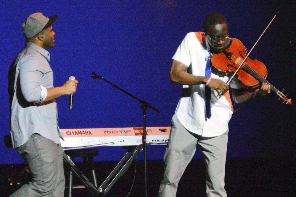 Kevin “Kev Marcus” Sylvester (left) pumps up the audience through song, while Wilner “Wil B.” Baptiste plays on his viola, “Tiffany.”​