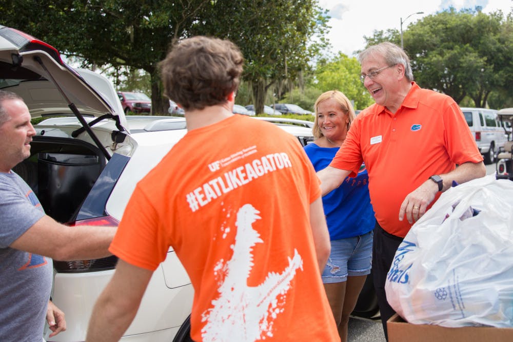 <p>President Kent Fuchs helps students move in on Thursday, Aug. 15 at Jennings Hall. </p>