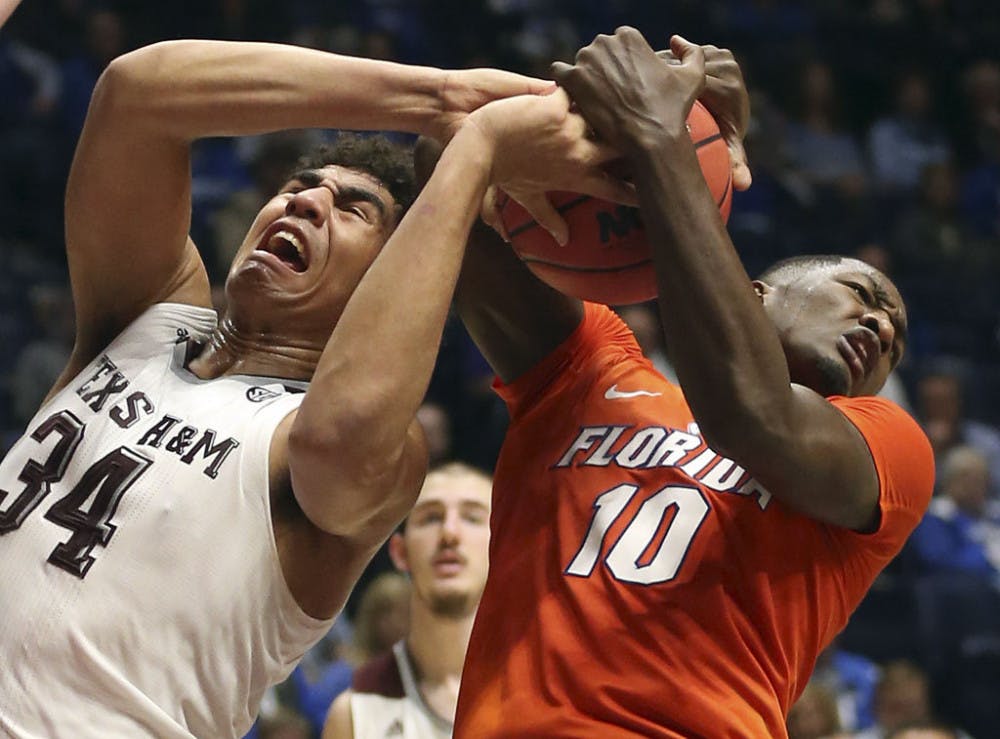 <p>Texas A&amp;M's Tyler Davis (34) and Florida's Dorian Finney-Smith (10) battle for a rebound during the first half of an NCAA college basketball game in the Southeastern Conference tournament in Nashville, Tenn., Friday, March 11, 2016. (AP Photo/John Bazemore)</p>