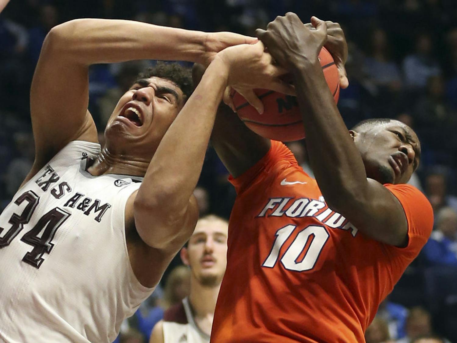 Texas A&M's Tyler Davis (34) and Florida's Dorian Finney-Smith (10) battle for a rebound during the first half of an NCAA college basketball game in the Southeastern Conference tournament in Nashville, Tenn., Friday, March 11, 2016. (AP Photo/John Bazemore)
