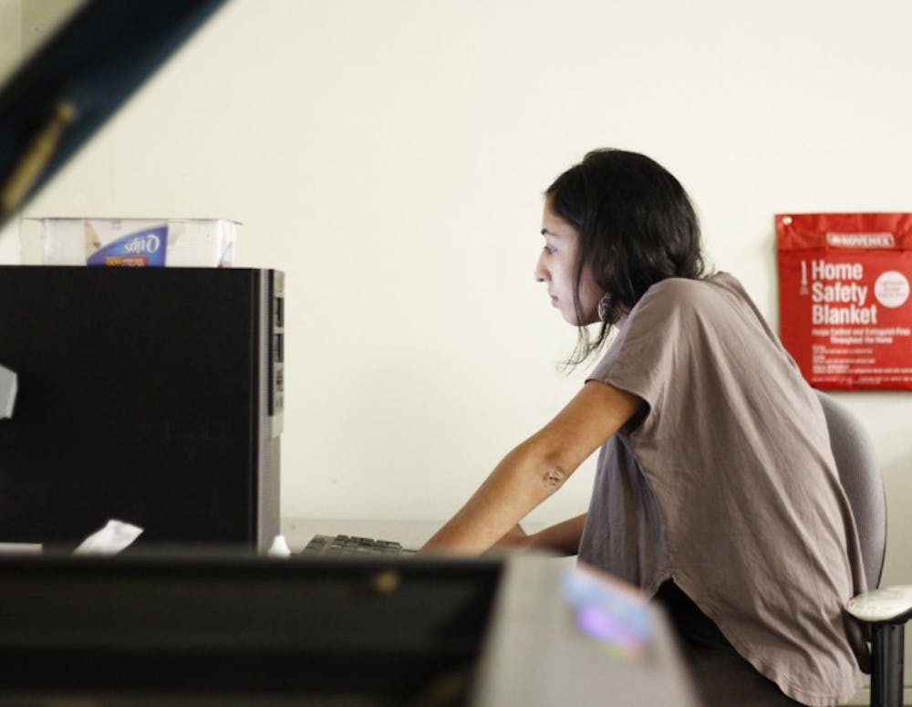 <p>Sorina Vaziri, a 21-year-old UF art senior, uses a computer in the A2 Fab Lab to design her flower pattern that will be engraved on animal hide.</p>