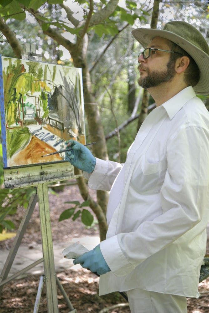 Frank Barone, a 50-year-old Gainesville painter, sketches the outline of his painting during the Paint Out at Kanapaha Botanical Gardens Sept. 13, 2015. Barone was among many local artists invited to participate in the three day event promoting art as a universal language.