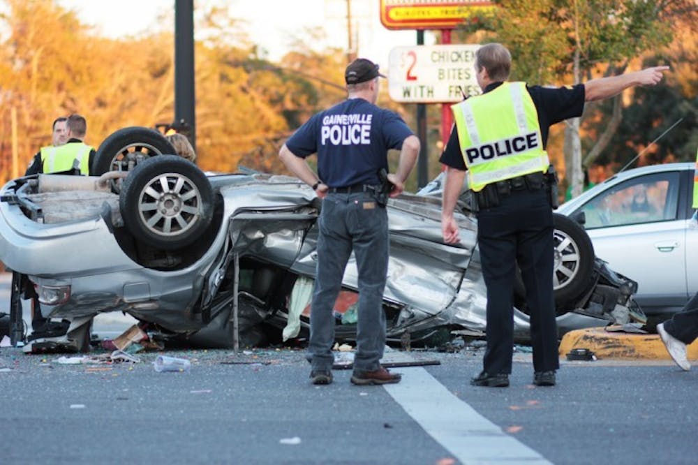 <p>Gainesville Police survey a five-car crash that left one car flipped at the intersection of 34th Street and University Avenue on Sunday, Jan. 8.</p>