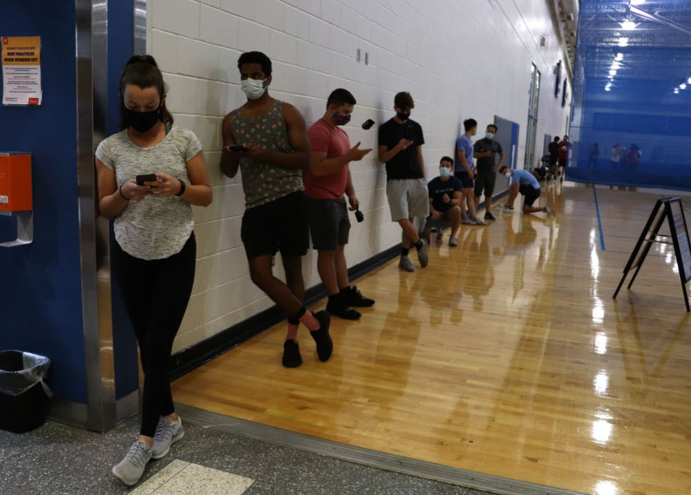 People stand in line to enter the weight room at the Southwest Recreation Center in Gainesville on Monday night, Sept. 21, 2020. According to recsports.ufl.edu, the weight room is open at limited capacity, however the website does not state how many people are allowed at one time.