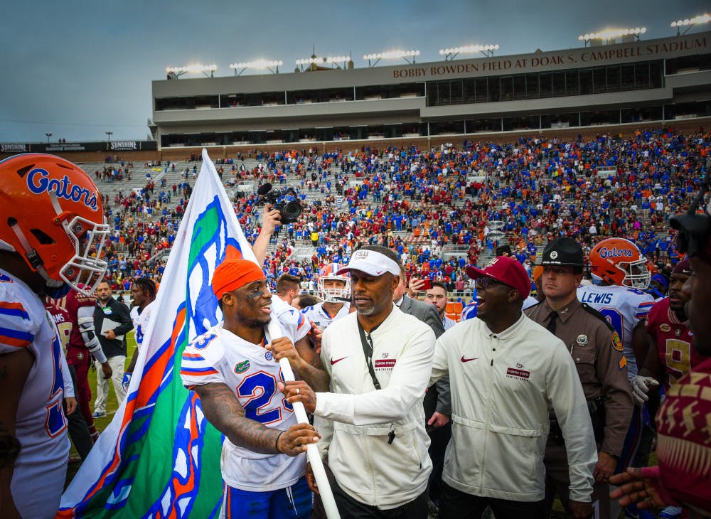 Florida State coach Willie Taggart stops Florida safety Chauncey Gardner-Johnson from planting a UF flag at midfield following the Gators’ 41-14 win over the Seminoles at Doak Campbell Stadium on Saturday. 