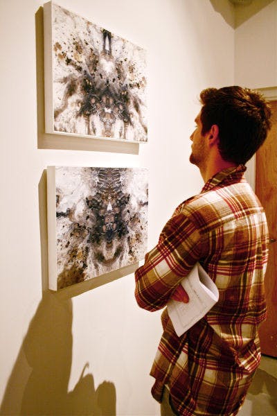 Drawing senior Domenic Henderson,21, admires the work of fellow artist Alexa Udermann, a drawing senior, at the WARPhaus gallery. The artists’&nbsp; work will be on display through Feb. 6.