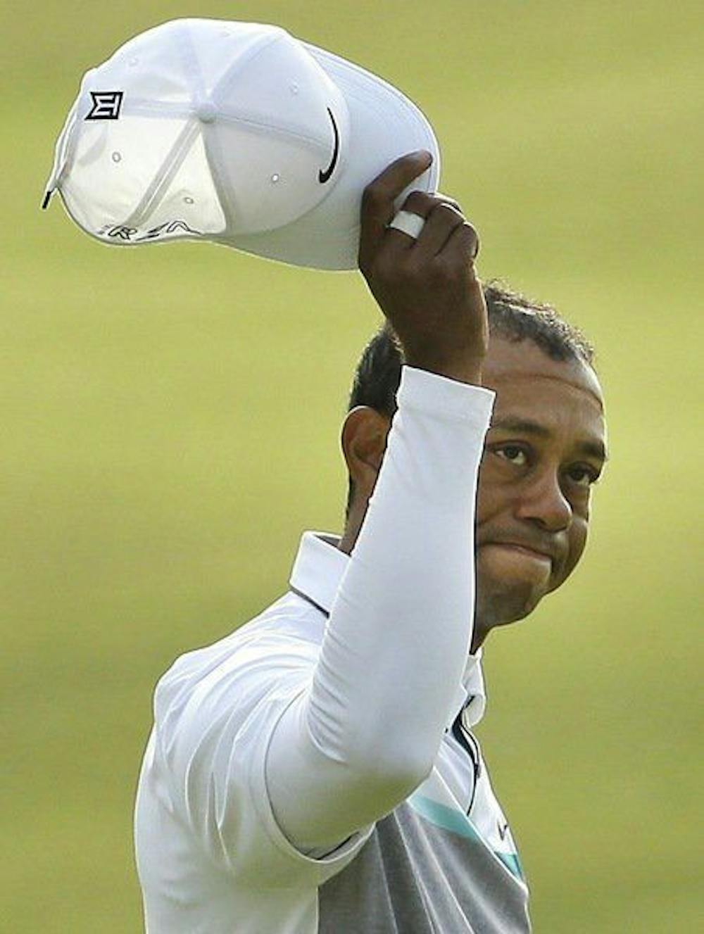 <p>Tiger Woods tips his cap as he walks on the 18th hole during Friday's second round of the British Open.</p>