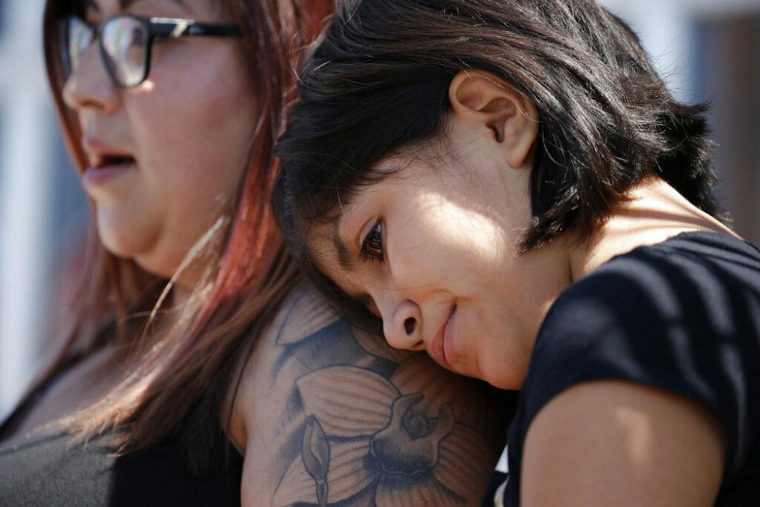 Eleven-year-old Leilani Hebben puts her head on her mother Anabel Hebben's shoulder as they visit the scene of a mass shooting at a shopping complex Sunday, Aug. 4, 2019, in El Paso, Texas.&nbsp;