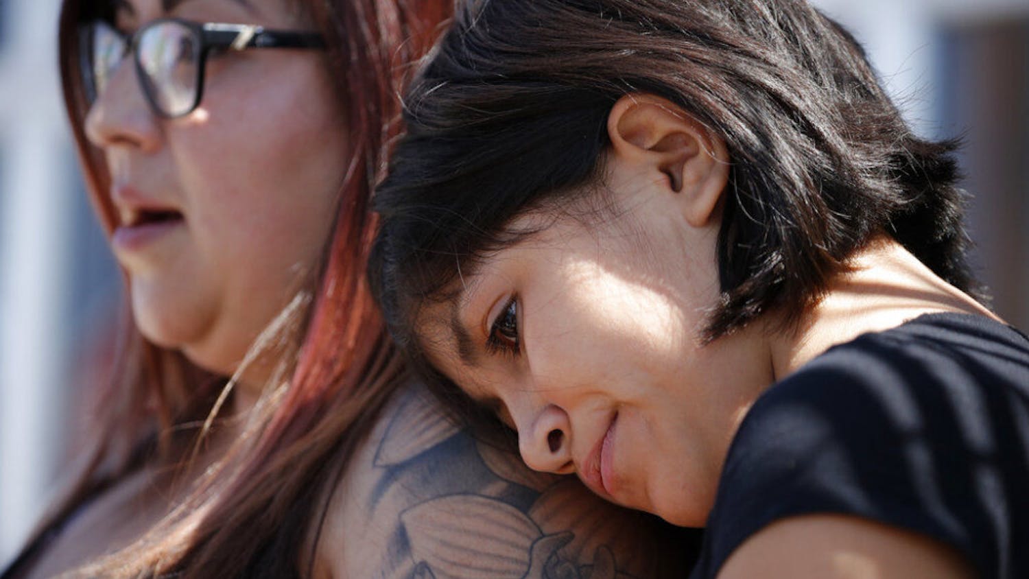 Eleven-year-old Leilani Hebben puts her head on her mother Anabel Hebben's shoulder as they visit the scene of a mass shooting at a shopping complex Sunday, Aug. 4, 2019, in El Paso, Texas. 