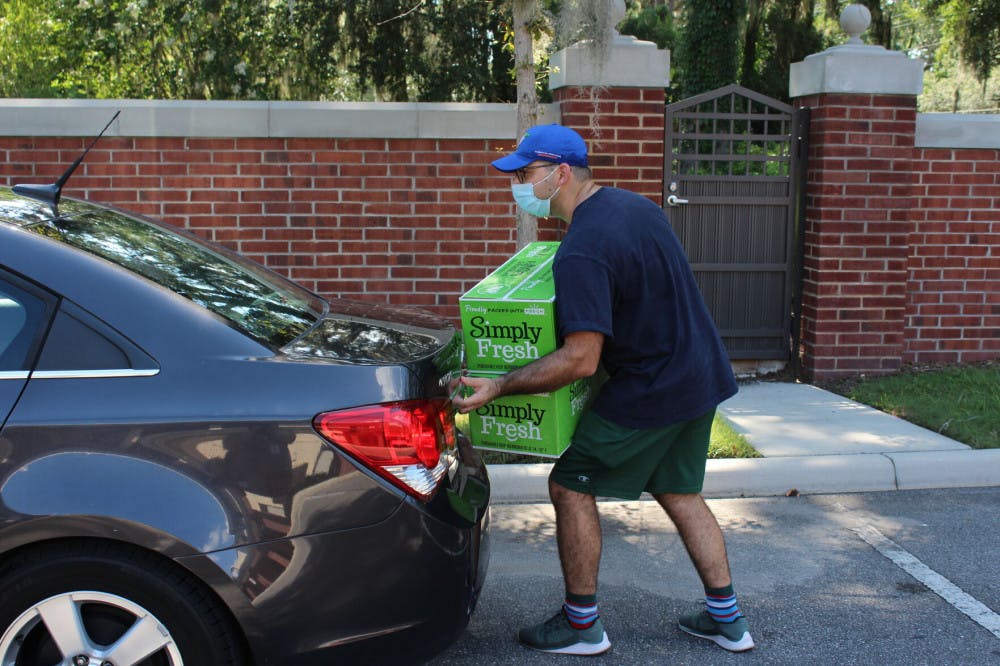 Hanan Walters, a recent University of Florida graduate with a degree in economics, loads boxes into the trunk of a car. Walters is an active member of the Lubavitch Chabad Jewish Center of Gainesville and frequented the weekly Friday dinners, and spent the afternoon of July 16 volunteering to haul boxes and direct traffic at the drive-through food drive.