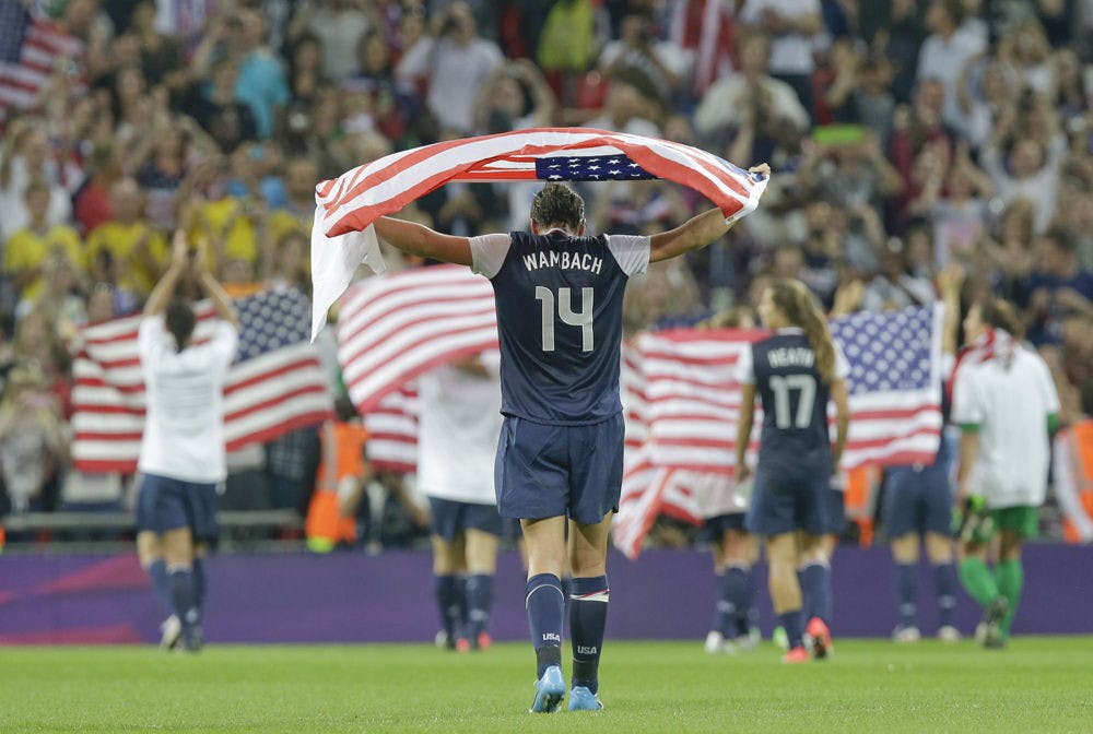 <p>Abby Wambach, draped in an American flag, celebrates with teammates after winning the women's soccer gold medal match against Japan at the 2012 Summer Olympics.</p>
