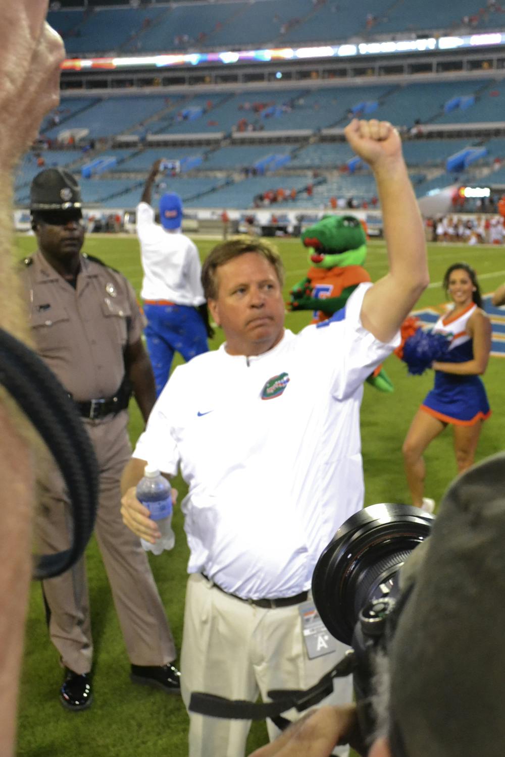 UF coach Jim McElwain Gator Chomps after Florida's 27-3 win against Georgia on Oct. 31, 2015, at EverBank Field in Jacksonville.