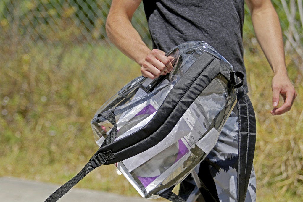 A student carries a clear backpack outside of Marjory Stoneman Douglas High School in Parkland, Fla., Monday, April 2, 2018. The bags are one of a number of security measures the school district has enacted as a result of the Feb. 14 shooting at the school that killed 17.&nbsp;