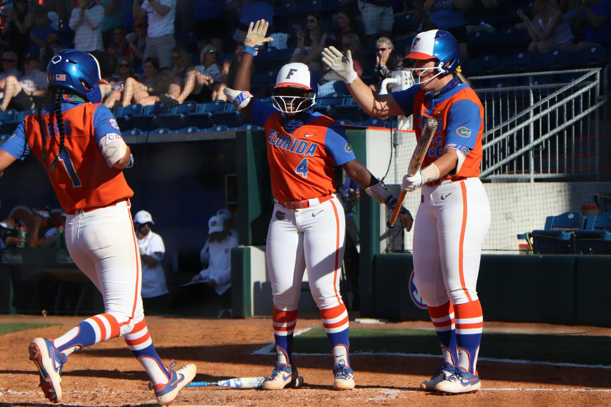 Charla Echols, Hannah Adams and Kendyl Lindaman celebrate at home plate. 