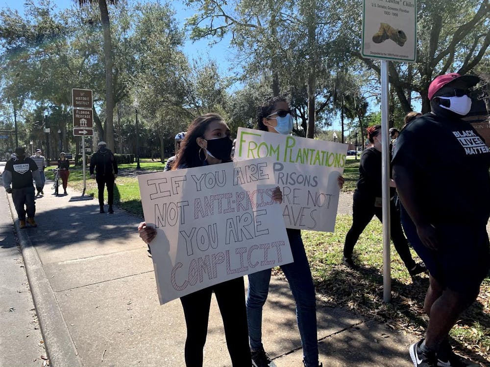 <p>Brianna Alderman (Left) and Camile Hagins (Right) hold up homemade signs as they march in support of antiracism on Feb. 20, 2021.</p>