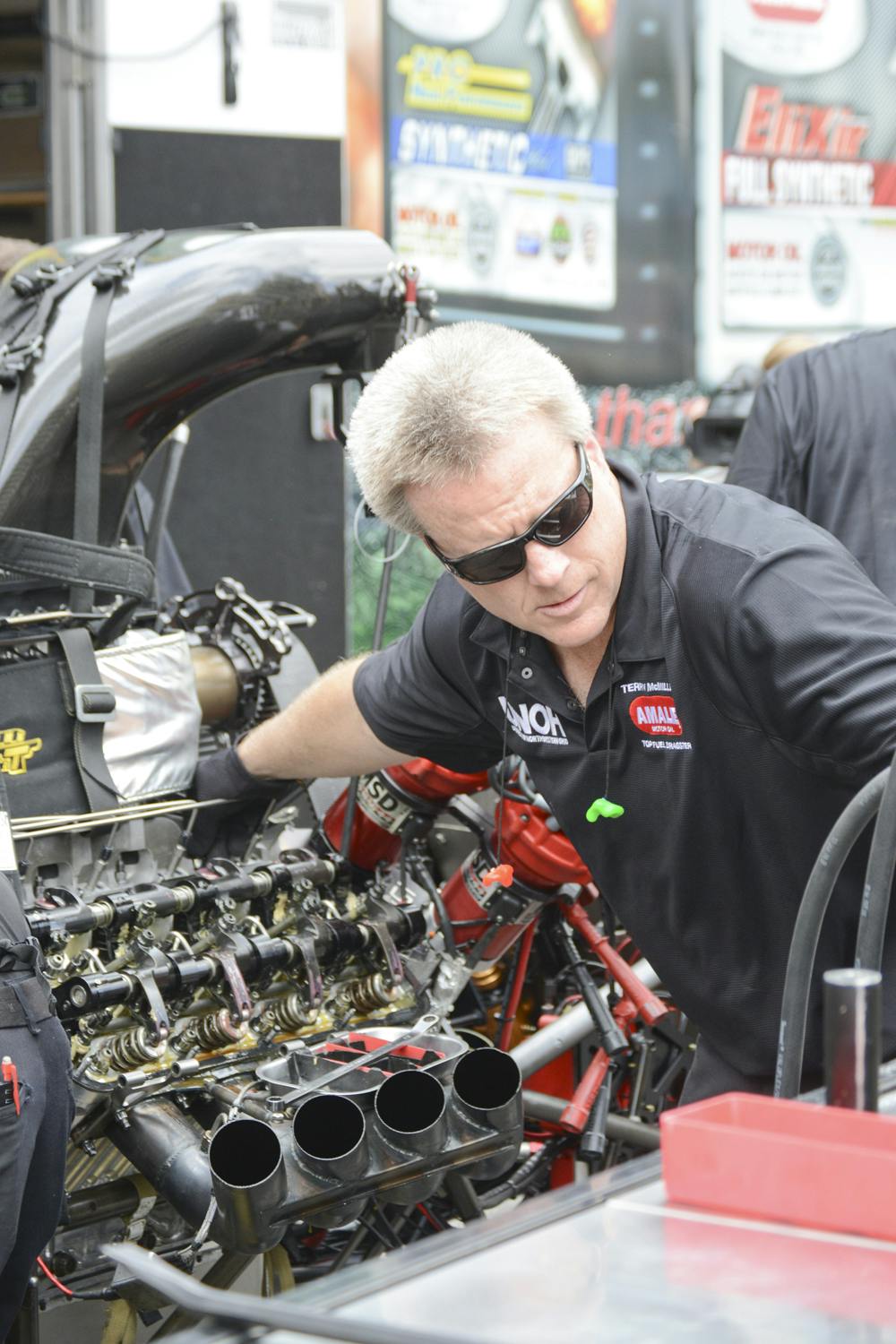 <p>A member of drag racer Terry McMillen’s pit crew services the Top Fuel dragster at a National Hot Rod Association media event near Piesano’s Pizza on Wednesday at noon. Pit crew members at the event demonstrated starting the dragster’s engine, removing it, rebuilding it and then reattaching it before starting it again.</p>