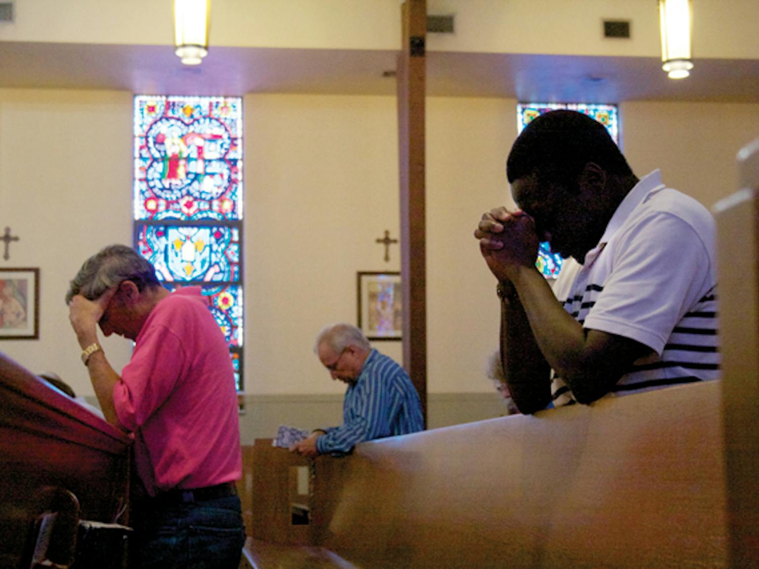 St. Augustine Church members pray before noon Mass. According to a recent study, women who regularly attended religious services were 56 percent more likely to be optimistic and 27 percent less likely to show signs of depression.