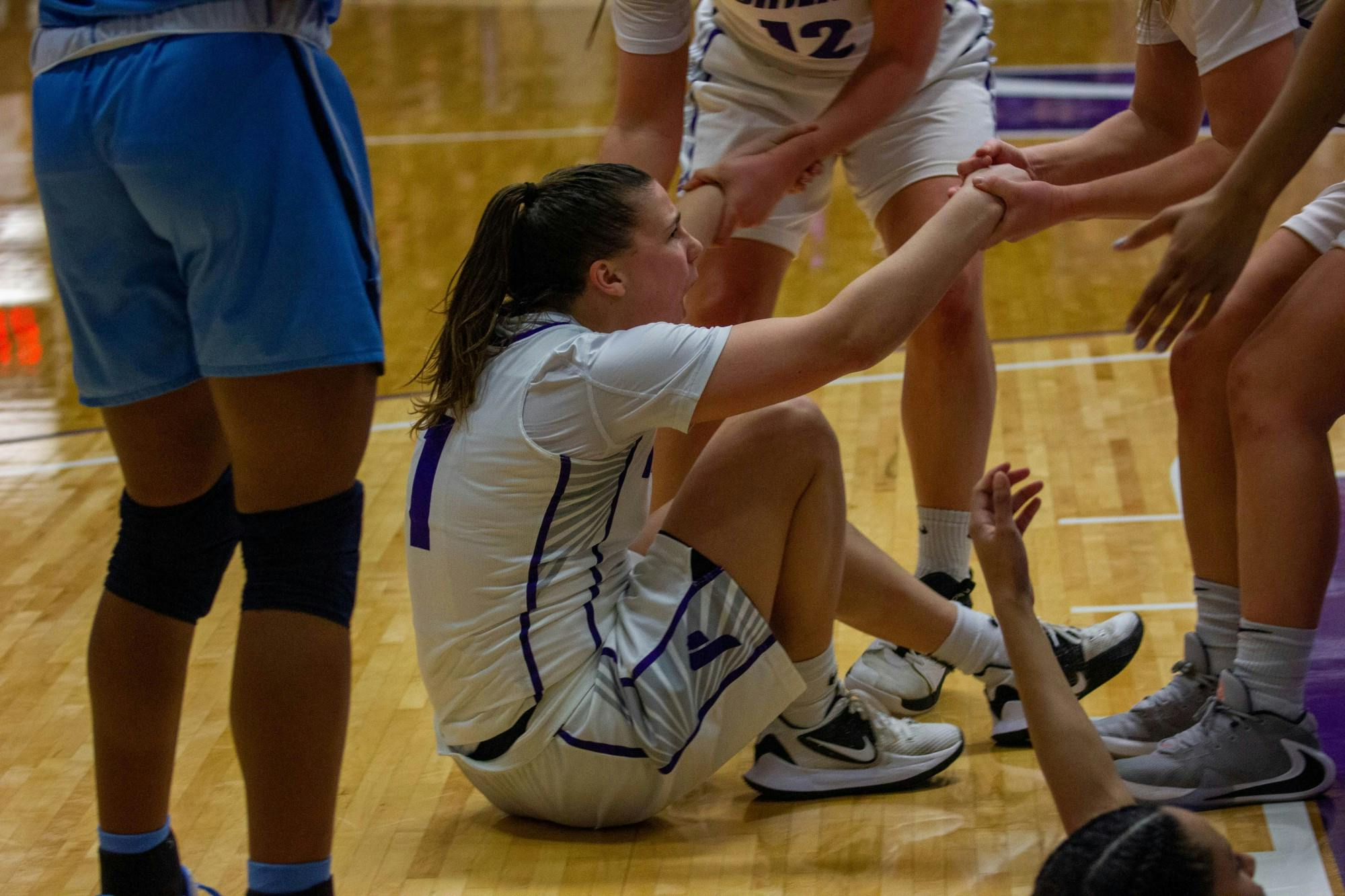 Senior Kate Andersen is helped up by her teammates.