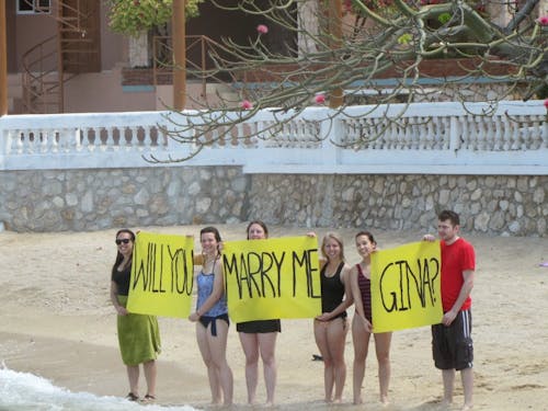  Students and staff stand on the beach in Haiti, holding Donovan's proposal sign: "Will you marry me Gina?" Photo courtesy of Gina Loschiavo