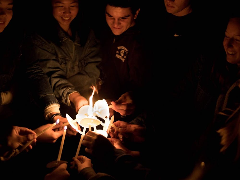 Members of Owen Klinger's workshop group unite their candles.
