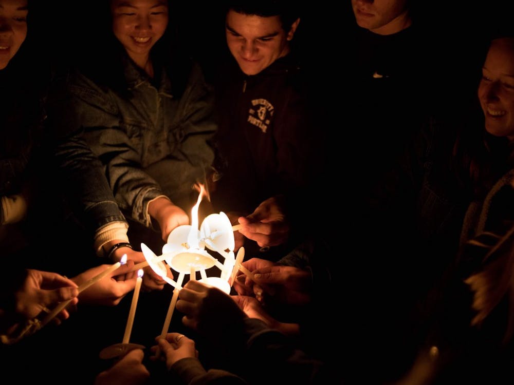 Members of Owen Klinger&#x27;s workshop group unite their candles.