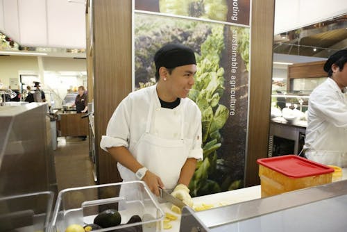  Junior Matthew Mun prepares lemons at the Commons sushi station. Mun is working towards a business degree, as well as balancing an additional job at the Nike factory store in Portland.Photo by Becca Tabor 