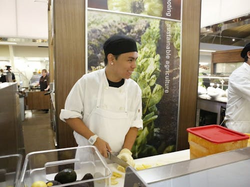  Junior Matthew Mun prepares lemons at the Commons sushi station. Mun is working towards a business degree, as well as balancing an additional job at the Nike factory store in Portland.Photo by Becca Tabor 