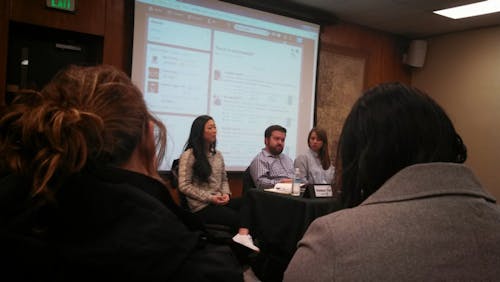  (Left to right) Panelists Kamauri Yeh, Mike Bodine and Laura Atwell lead a discussion of social media in the workplace. Behind them, audience members tweet commentary using the hashtag "#socmediaUP". Photo by Clare Duffy