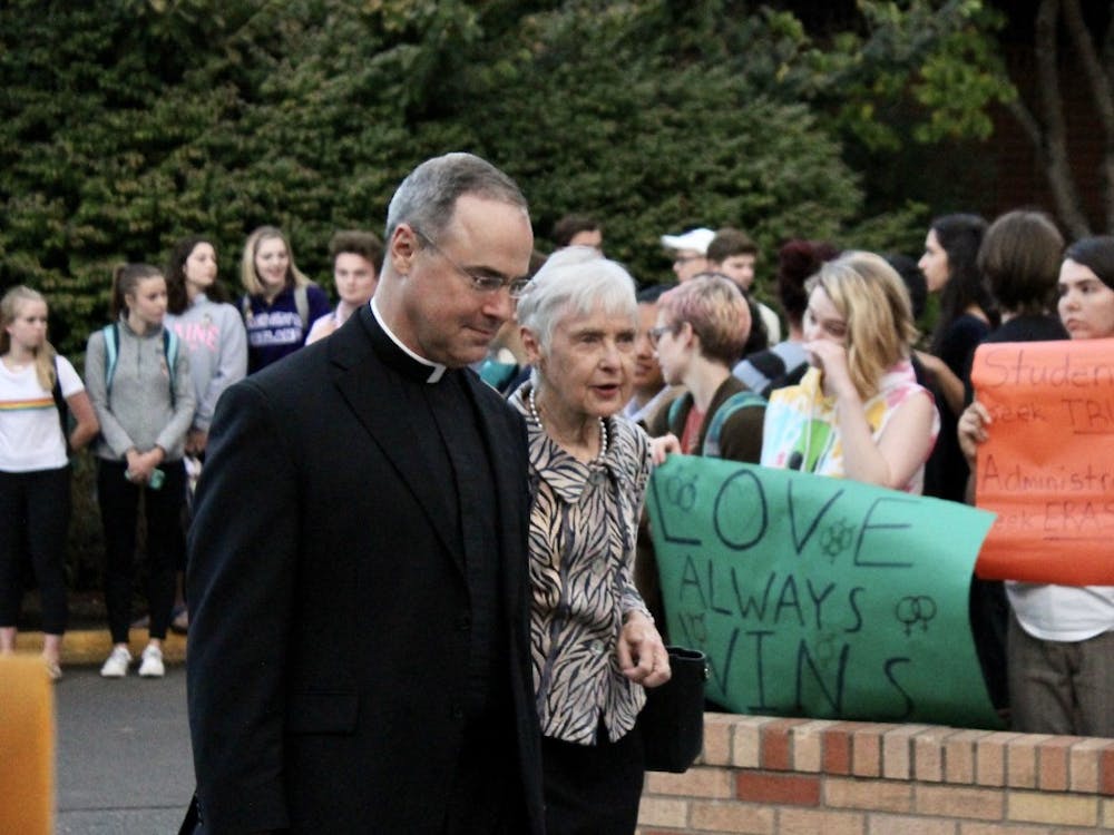 Fr. Paul Scalia passes through the protest with his mother, Maureen Scalia, widow of Supreme Court Justice Antonin Scalia. ASUP organized the demonstration to protest Scalia's involvement in an anti-LGBTQ group and statements he has made about homosexuality.