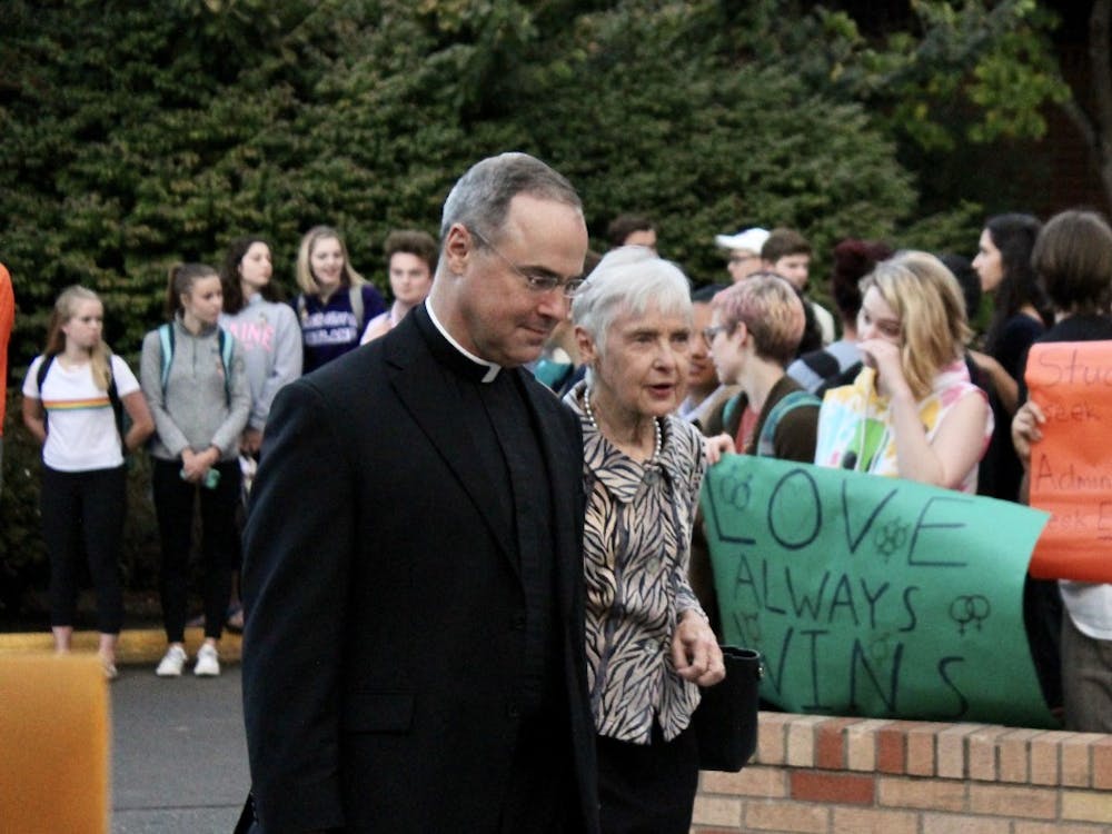 Fr. Paul Scalia passes through the protest with his mother, Maureen Scalia, widow of Supreme Court Justice Antonin Scalia. ASUP organized the demonstration to protest Scalia's involvement in an anti-LGBTQ group and statements he has made about homosexuality.