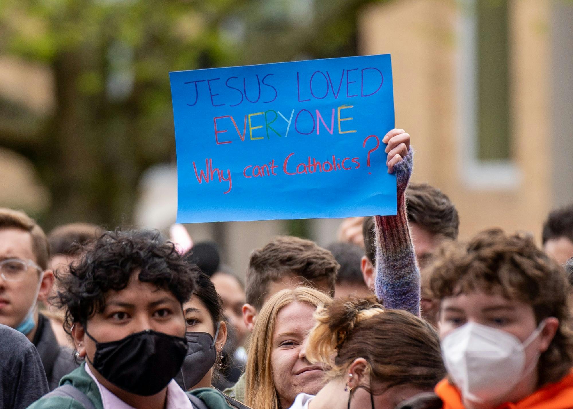 A student holds a "Jesus loved everyone why can't Catholics" sign at the Fr. Dan protest.
