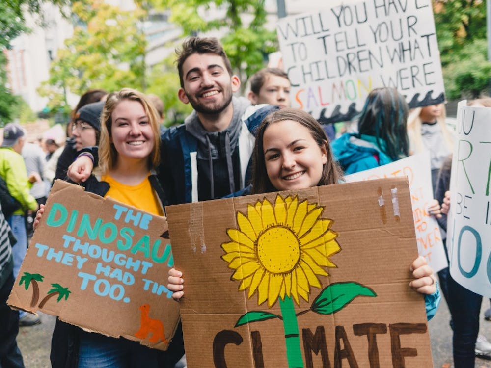 UP Students smile with their handmade signs at the Portland Climate Strike. 