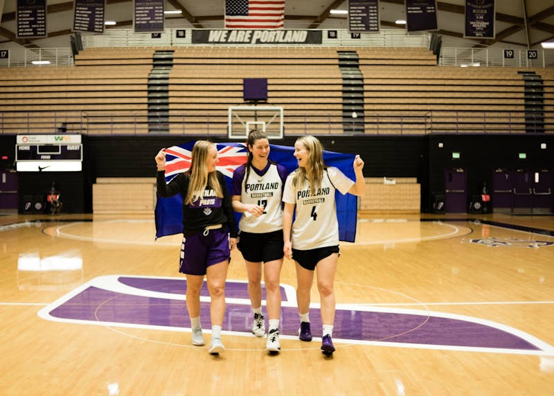 (From left to write) Haylee Andrews, Alex Fowler, and Keeley Frawley walk down the court with the Australian flag wrapped around them.