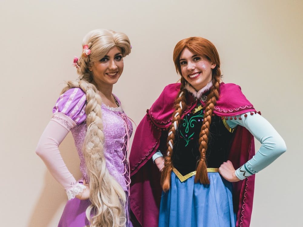 Two princesses pose after attending a hospital visit. They're a part of UP's chapter of A Moment of Magic, a non-profit where college students dress as children's favorite characters and visit them in the hospital.