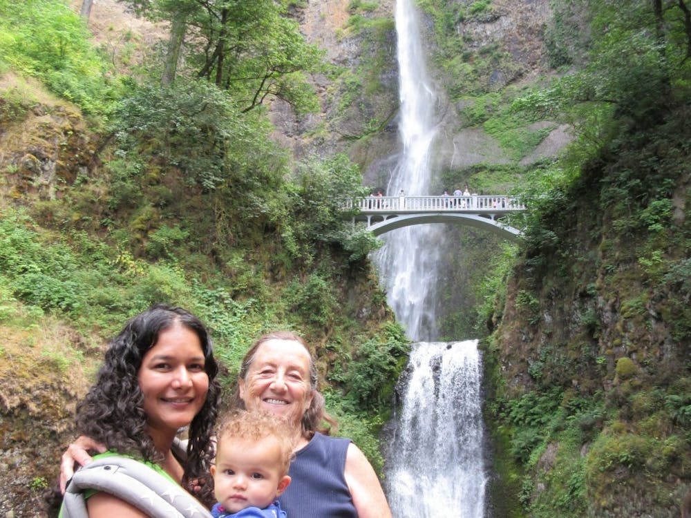 Psychology Professor Sarina Saturn (left) says that Multnomah Falls has always been one of her favorite places in the world. Here she is pictured with her then infant daughter, Sia, and a close friend. Photo courtesy of Sarina Saturn. 