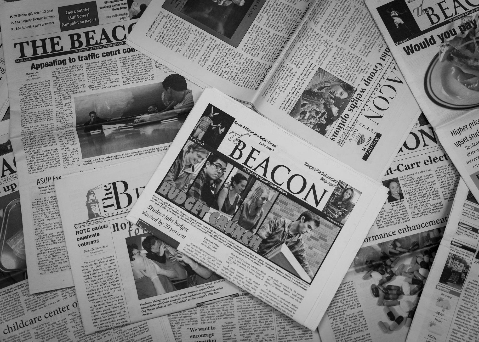 Printed volumes of The Beacon sit scattered on a table.