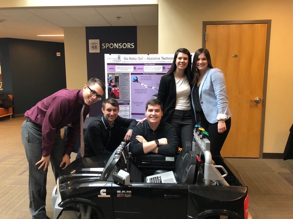 Team members Jacob Wolwowicz, Parker Elliot, Ally Fox, Philipp Holzmann and Laura Pickering pose in front of a Dodge Ram Power Wheel Car, which was provided to them by Go Baby Go. Photo courtesy of Pickering.&nbsp;