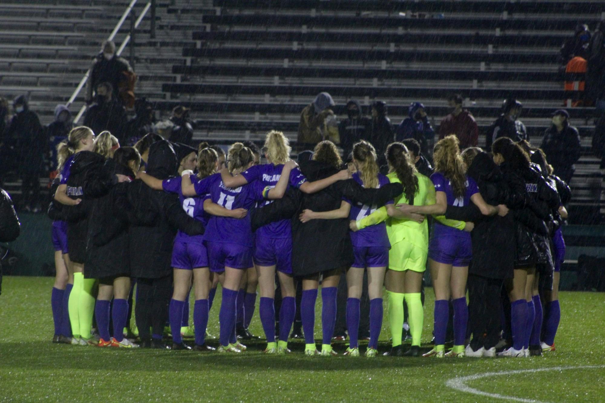 The UP women's soccer team shares a group huddle after their last home game of the season.