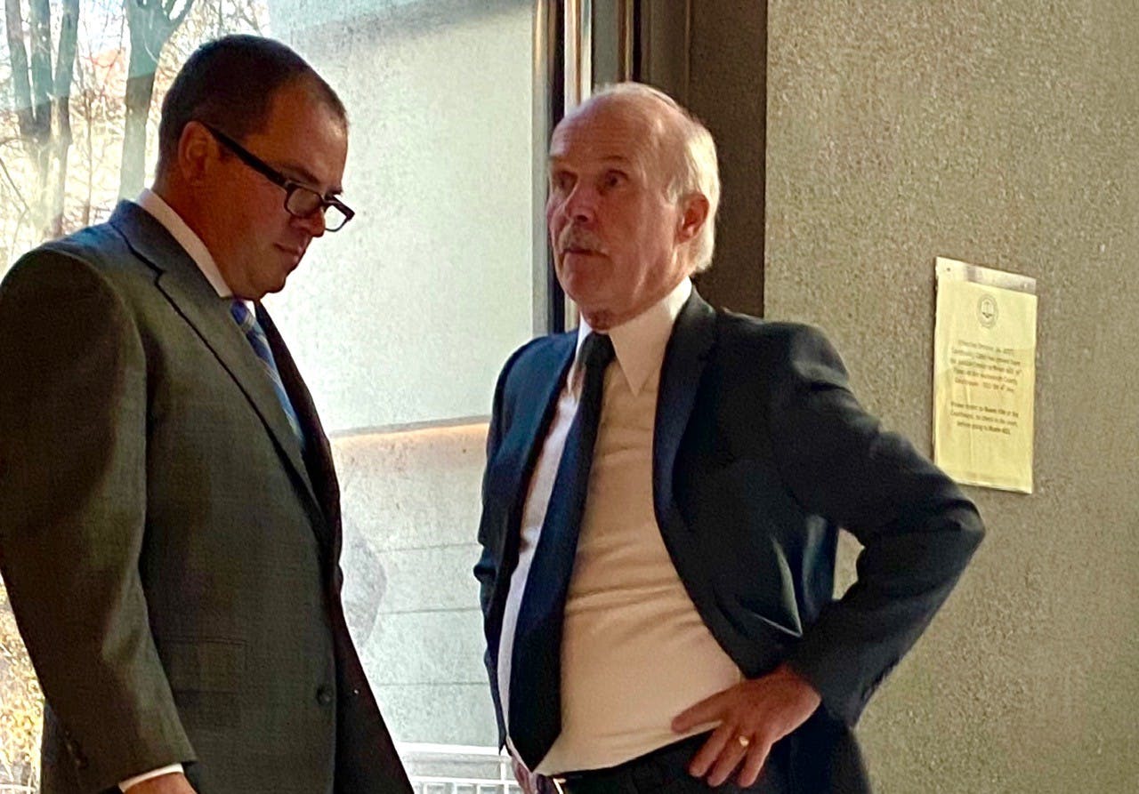 Patrick Ell waits outside the courtroom with his attorney, Stephen Houze. Ell is charged with Second Degree Assault, a felony.
