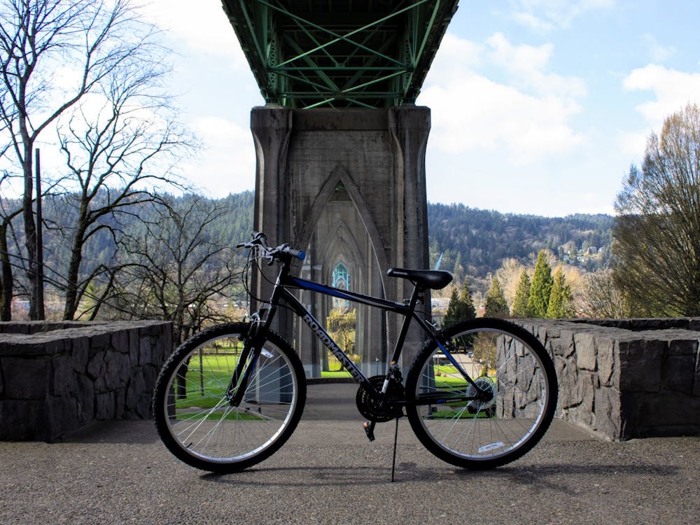 A bike sits below St. Johns Bridge at the entrance to Cathedral Park. Biking is a great way to get across town while staying active.