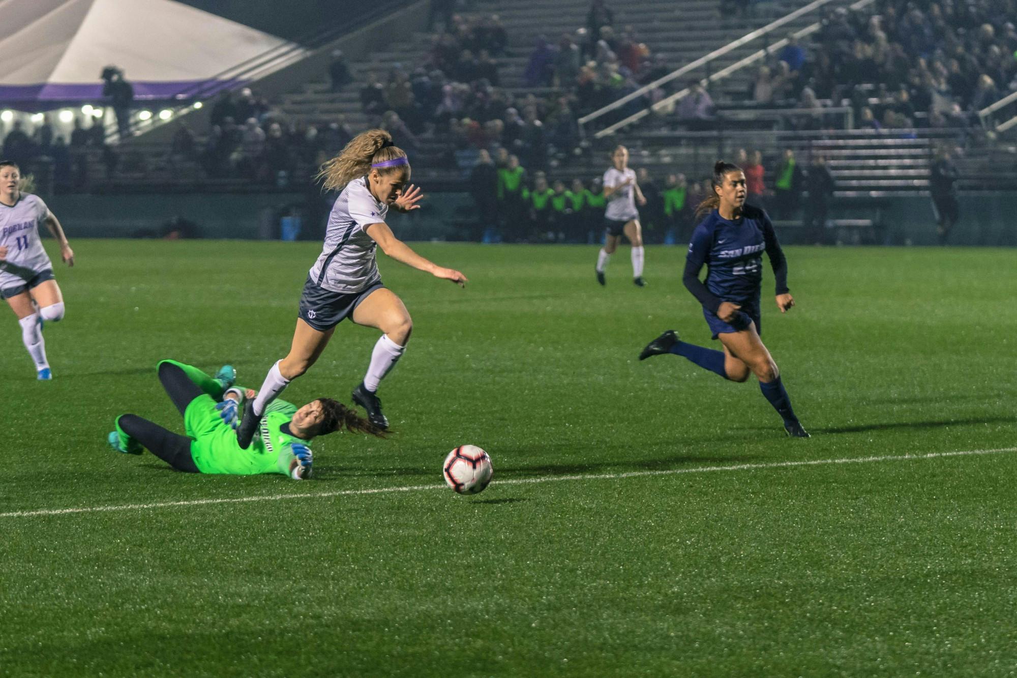 Senior forward Kimberly Hazlett leaps over the keeper and heads towards the goal.