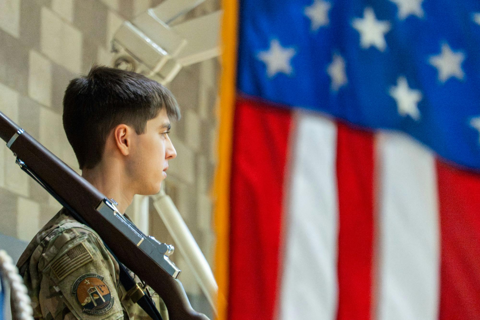 An Air Force ROTC cadet stands behind the United States flag.