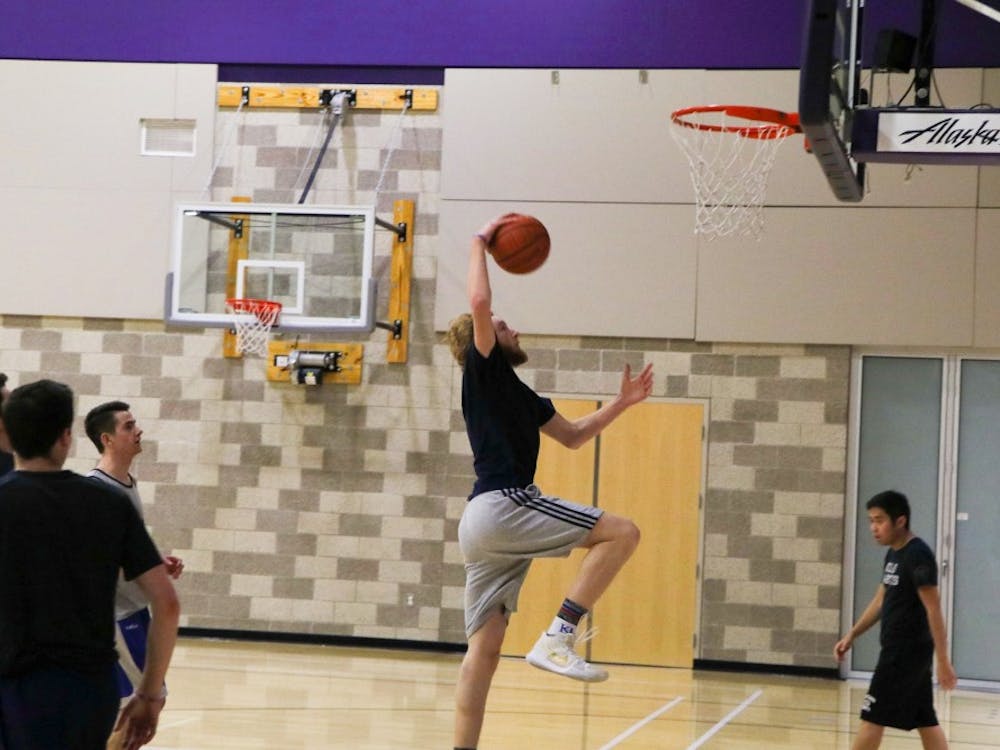 Freshmen Dylan de Jong goes up for a dunk at club basketball practice.