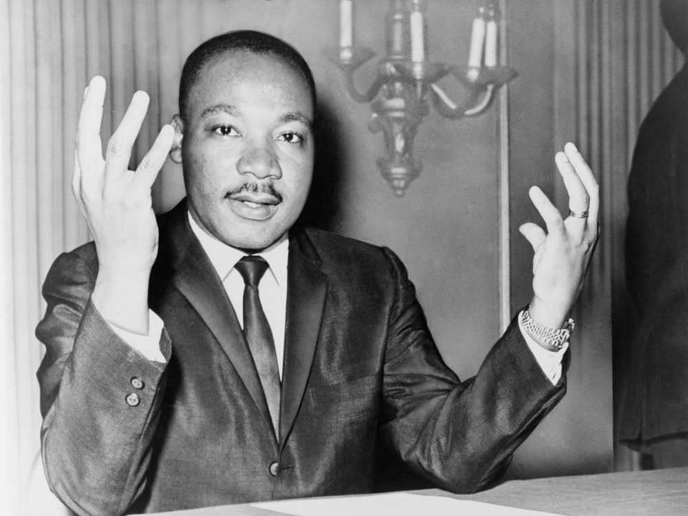 Rev. Martin Luther King, head-and-shoulders portrait, seated, facing front, hands extended upward, during a press conference / World Telegram & Sun photo by Dick DeMarsico. Photo: Wikimedia Commons