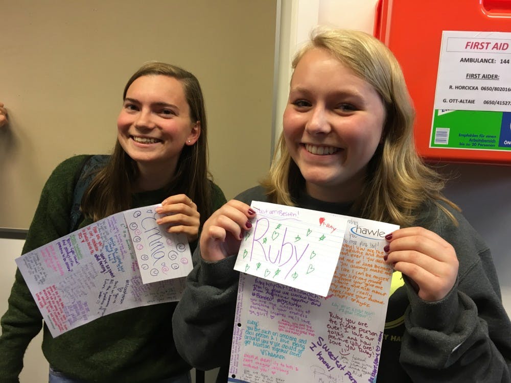 Emma Wells and Ruby Lindgren hold up compliment cards they received from other members of Active Minds in Salzburg. Photo courtesy of Kylie Koney.
