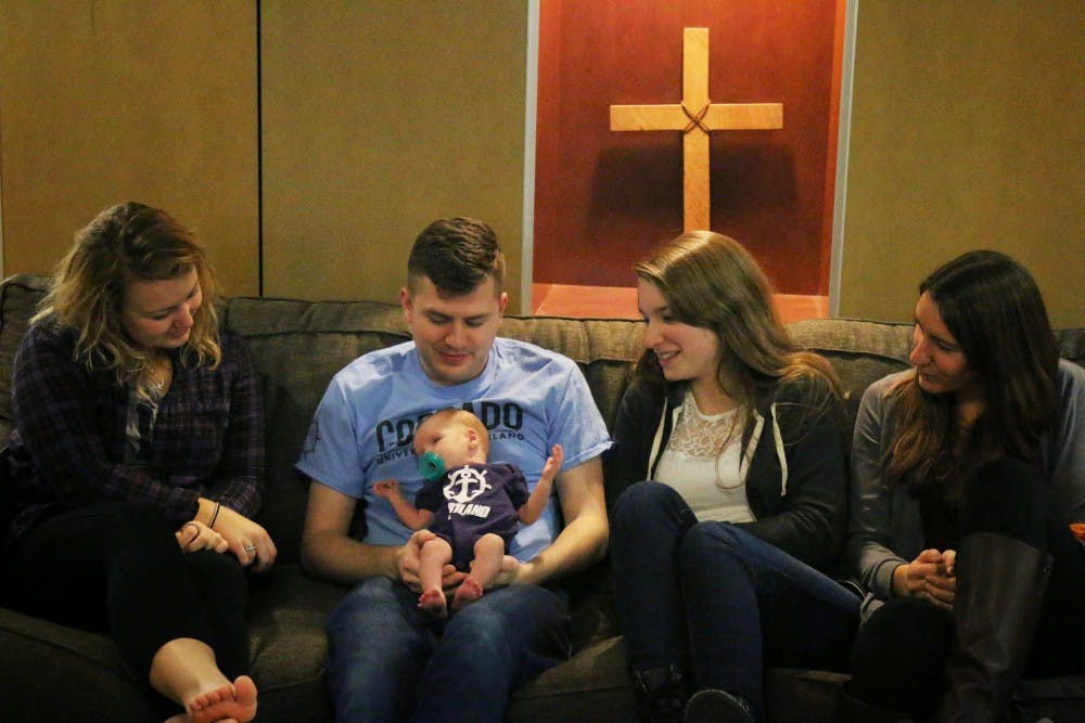  From left to right, Shannon O'Leary, Mike Wode, Jen Richey and Michalah Leffler adore Gregory Wode, who moved into Corrado this month. Mike Wode says his son has become an integral part of the Corrado community since Mike and his wife Jessica adopted him. Photo by Parker Shoaff