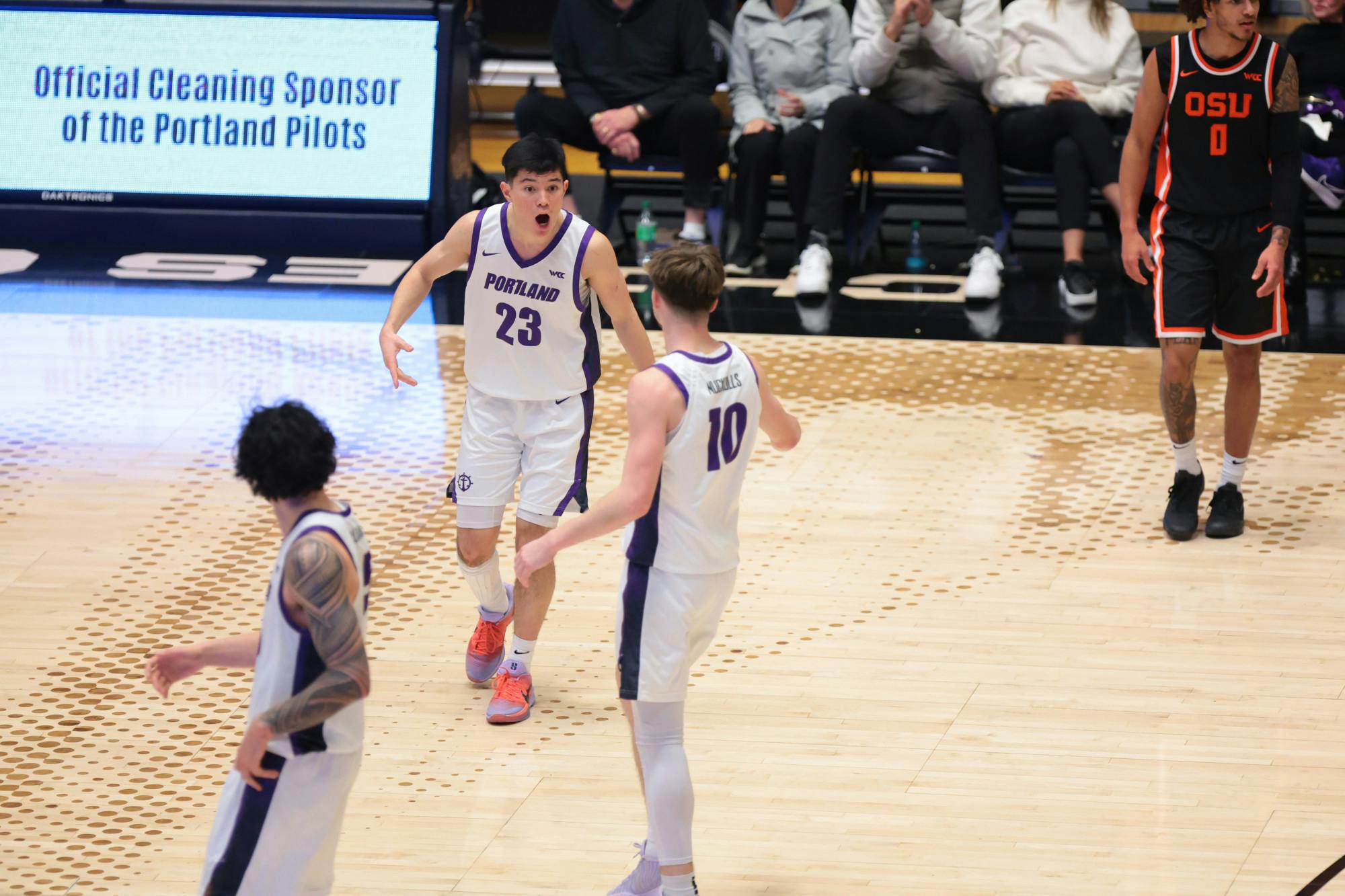 Freshman guard Joel Foxwell celebrates with junior guard Garrett Nuckolls in a win against Oregon State. Photo courtesy of Portland Pilots Digital Media.