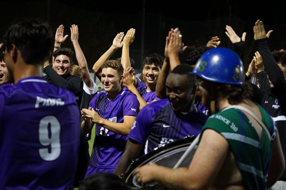 Pilots celebrate with the Villa Drum Squad after their win against Corban.