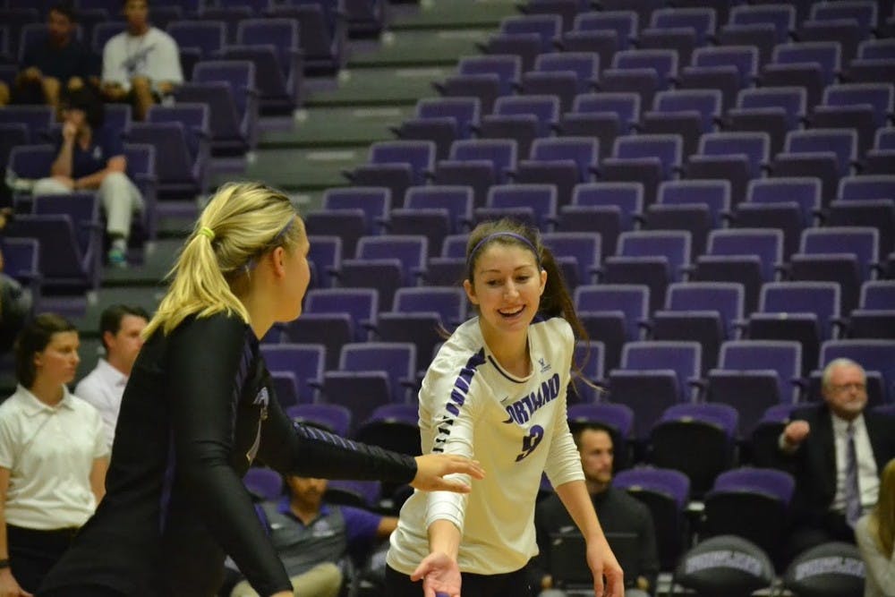  Photo by Thomas Dempsey | Morgan Robinson (right) and Monica Gajda high five. While Robinson is listed as an outside, she played libero in the tournament. She recorded 13 digs in the match against St. Francis and Gajda recorded 10.