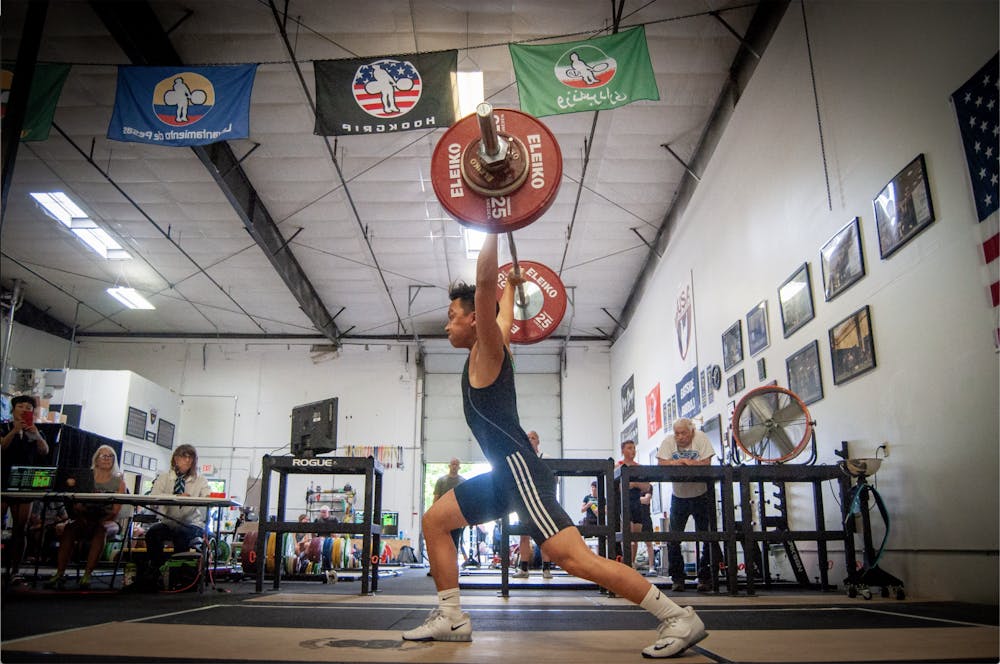 Tu doing a clean overhead at the Eastside Barbell Meet. Tu holds the record for snatch and clean and jerk in the 61kg weight class. Photo courtesy of Victor Tu